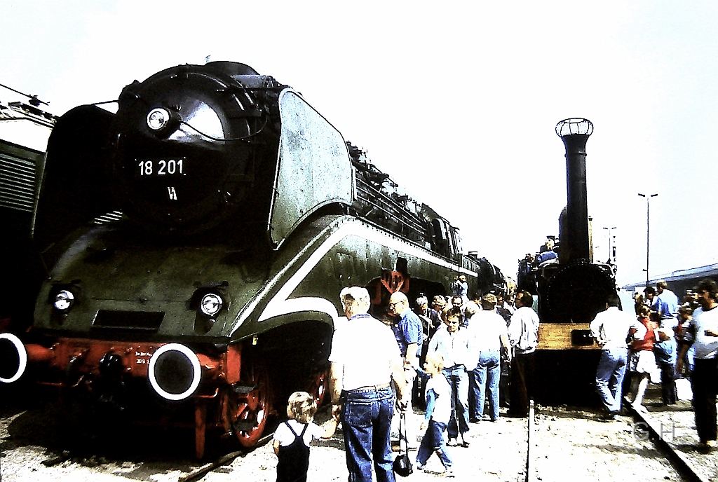 18_201_Gbh-Halle_1989_02(2).JPG - Im Jahre 1989 gab es auf den Güterbahnhof Halle zu seinen 100. Jährigen bestehen eine große Fahzeugschau. Hier auf den Ladegleisen der Güterabfertigung. Wobei links sich das Gebäude für die Güterabfertigung (Stückgut) befand. Die Fahrzeuge standen dicht gedrängt auf drei nebeneinanderliegenden Gleisen. Links im hintergrund die E18 03 und im Blick als erste Fahrzeuge die 18 201 und die Saxonia.