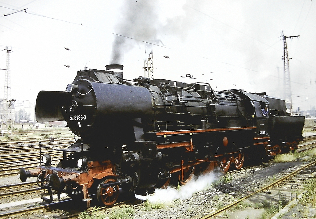 52_8186_Gbh-Halle_1989_07(2).jpg - Im Jahre 1989 gab es auf den Güterbahnhof Halle zu seinen 100. Jährigen bestehen eine große Fahrzeugschau an zwei Stellen. Hier mit den betriebsfähigen Maschienen und entsprechenden Fahrten. Der Ausstellungs-Ort war hinter der Zufahrtsstraße zum Verwaltungsgebäude des Güterbahnhofs am Ende der Viehrampe. Hier im Bild ist die 52 8186 bei einer Vorbeifahrt zu sehen.