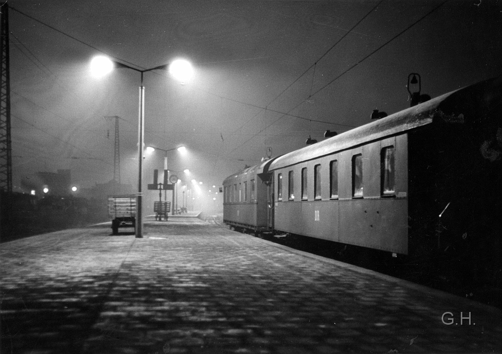 Bahnhof Halle (Saale)Bahnsteig 11-12.jpg - Bahnhof Halle / Saale der Bahnsteig 11/12. Links im Hintergrund ist links das ehemalige Reichsbahnausbesserungswerk auszumachen. Heute ist dieser Bahnsteig modernisiert. Wobei der Bogen im Bahnsteig noch vorhanden ist. Es gab auch Pläne diesen zu begradigen. Dafür ist es aber erforderlich die Gleise auf das ehemalige RAW-Gelände zu verlegen. Deren Gebäude sind aber ungenutzt noch vorhanden und stehen zudem unter Denkmalschutz. Zu diesen Foto kann ich keine weiteren Angaben machen, da es sich um ein Fund aus ex. DR Bestand handelt.