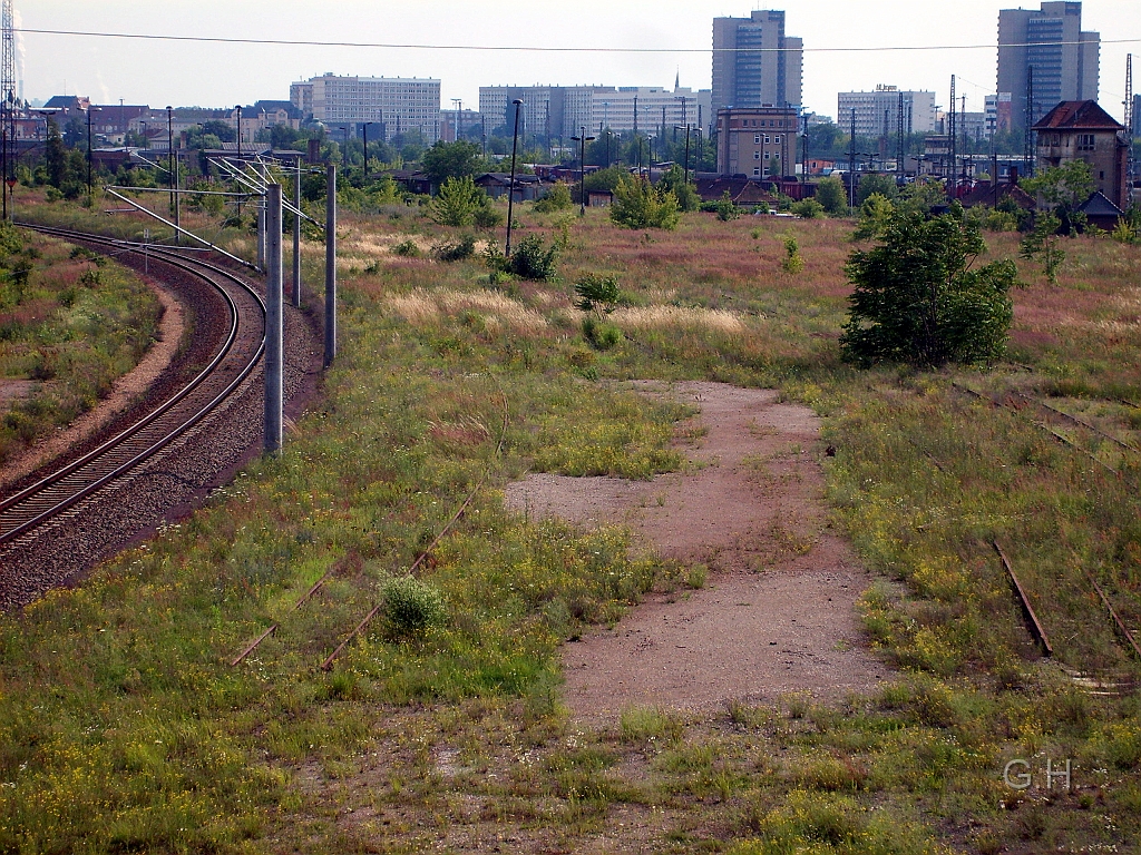 blick_Riebeckplatz_Gbh-Verw.geb_Hg8.003(2).JPG - Blick in Richtung Riebeckplatz mit den beiden noch vorhanden Hochhäusern und außerhalb des Bildes am linken Bildrand im Hintergrund ist der Hbf Halle / S. Das "neue" Gleis ist der Rest der umfangreichen Gleisanlagen vom Güterbahnhof-Südberg mit der jetzt noch vorhanden Umfahrung für den Hauptbahnhof um auch den jetzt noch genutzten Güterbahnhof-Nordberg zu erreichen. Vom rechten Bildrand beginnend ist das Stellwerk Hg 8., dann recht klein Hg 12. und dann das ehmalige Verwaltungsgebäude des Güterbahnhof Halle. Diese Verwaltungsgebäude steht schon sehr lange leer und es gibt schon seit längeren Pläne diese im Rahmen eines Umbau des Güterbahnhof Halle abzureißen.